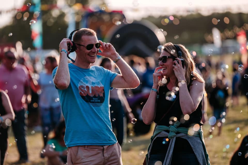 A man and lady enjoying a silent disco at a festival